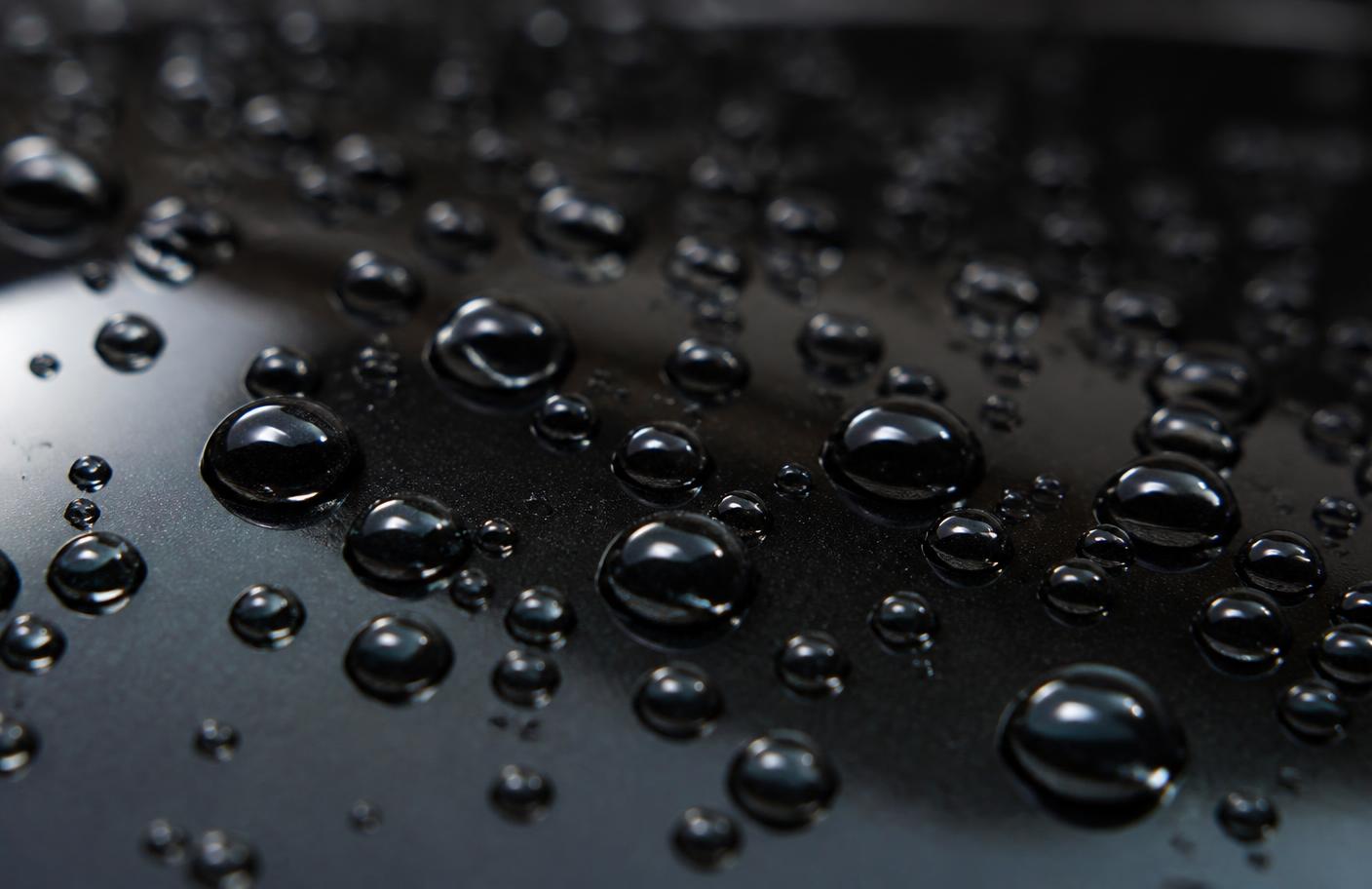 Water beading on a ceramic coated black car panel